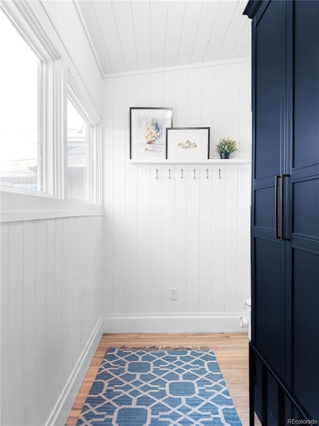 mudroom with ornamental molding, baseboards, and wood finished floors