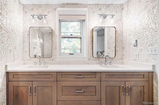 bathroom with double vanity, a sink, and wallpapered walls