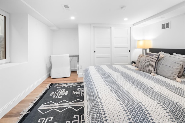 bedroom featuring visible vents, baseboards, light wood-style flooring, a closet, and recessed lighting