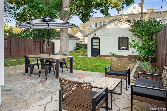 view of patio / terrace featuring fence, outdoor dining area, and an outdoor structure