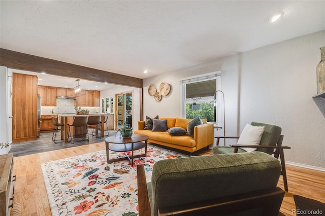 living area with light wood-type flooring, baseboards, and recessed lighting