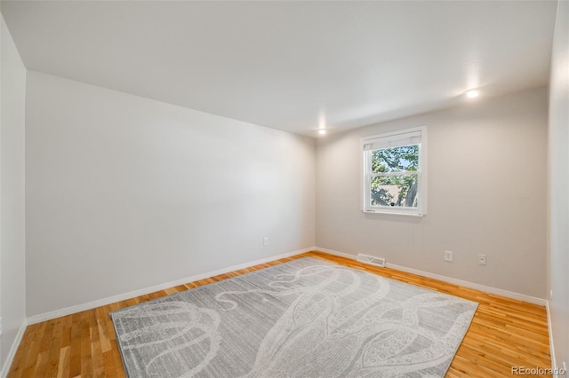 empty room featuring light wood finished floors and baseboards