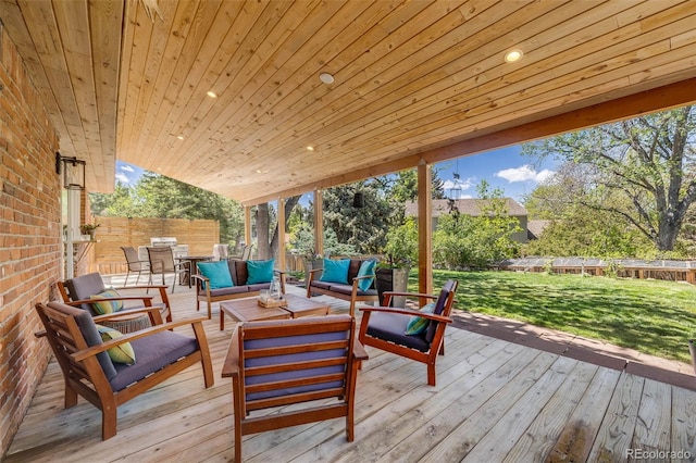 wooden terrace featuring outdoor lounge area and a lawn