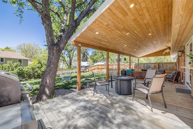 wooden deck with fence and an outdoor living space with a fire pit