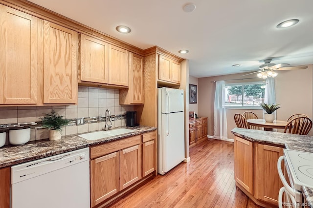 kitchen featuring white appliances, a ceiling fan, a sink, tasteful backsplash, and light wood-type flooring