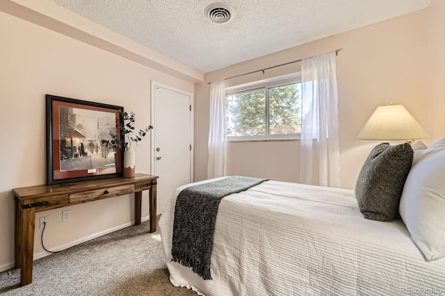 carpeted bedroom featuring visible vents and a textured ceiling