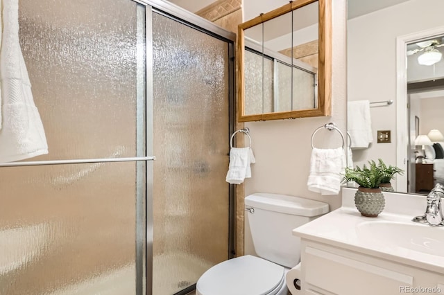 bathroom with toilet, a stall shower, and vanity