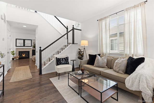 living room featuring dark wood-type flooring and a tiled fireplace