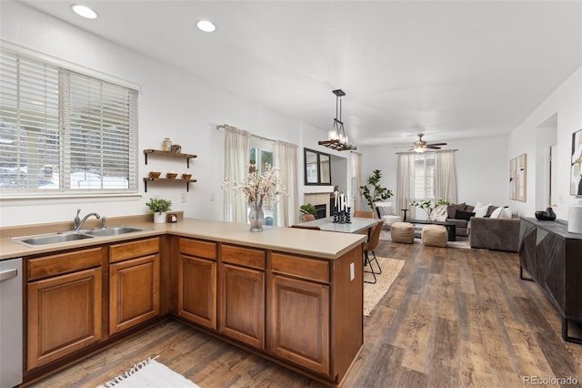 kitchen with sink, hanging light fixtures, ceiling fan, a healthy amount of sunlight, and kitchen peninsula