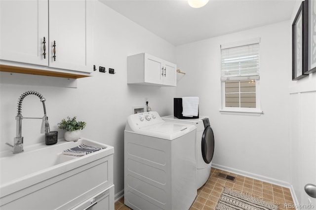 clothes washing area featuring cabinets, sink, and washing machine and clothes dryer