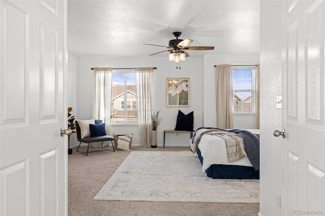 bedroom featuring carpet flooring, a textured ceiling, and ceiling fan