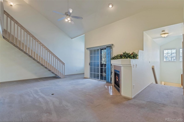 living room featuring light carpet, a ceiling fan, a fireplace with flush hearth, high vaulted ceiling, and recessed lighting