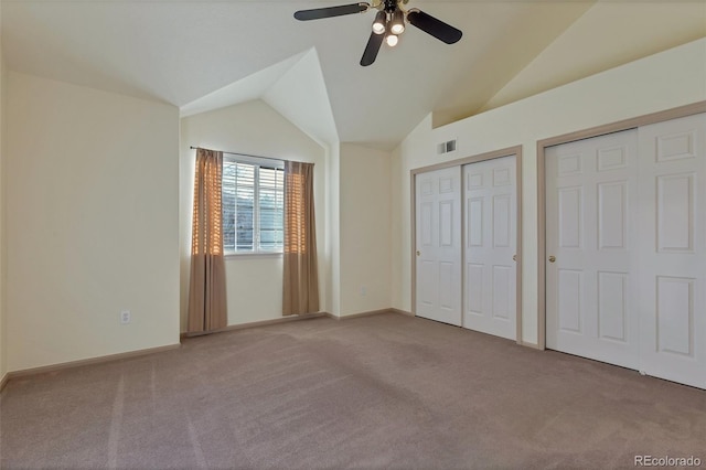 unfurnished bedroom featuring multiple closets, ceiling fan, light colored carpet, and lofted ceiling