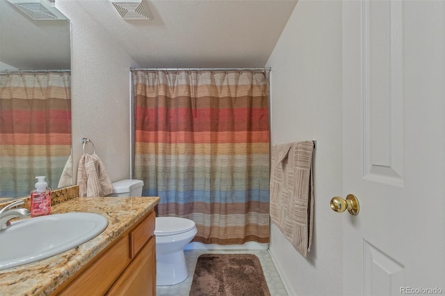 bathroom with tile patterned floors, vanity, toilet, and walk in shower