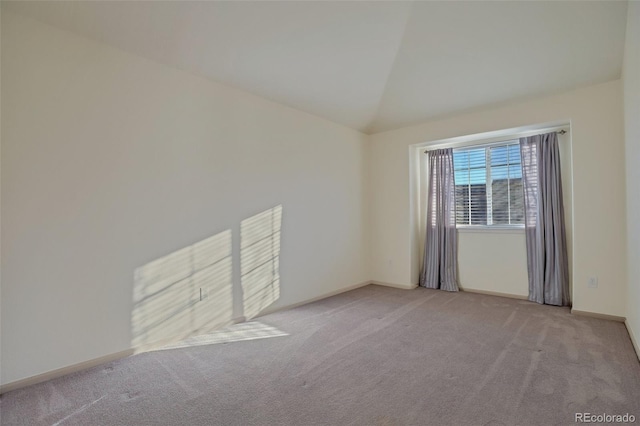 unfurnished room featuring light colored carpet and vaulted ceiling