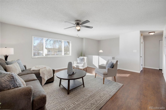 living room with hardwood / wood-style floors, a textured ceiling, and ceiling fan