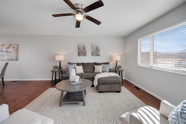 living room with ceiling fan, hardwood / wood-style floors, and a textured ceiling