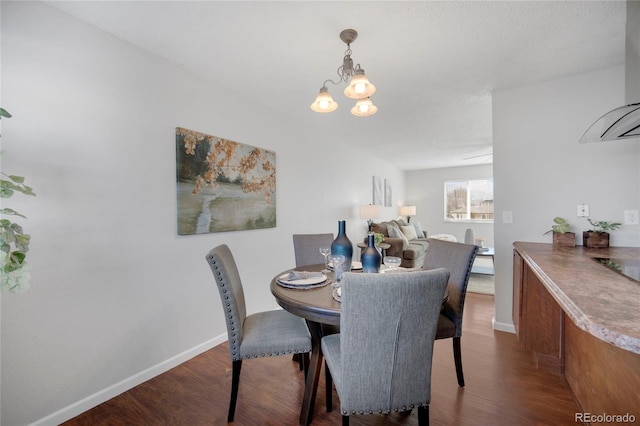 dining space featuring dark hardwood / wood-style flooring and a notable chandelier