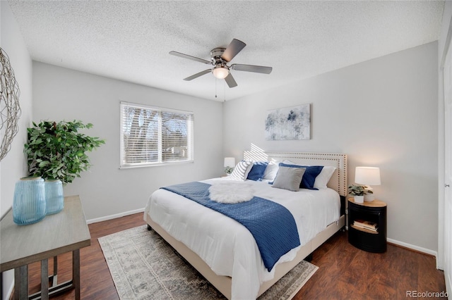 bedroom with ceiling fan, dark wood-type flooring, and a textured ceiling