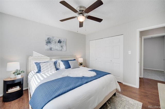 bedroom with dark wood-type flooring, ceiling fan, a closet, and a textured ceiling