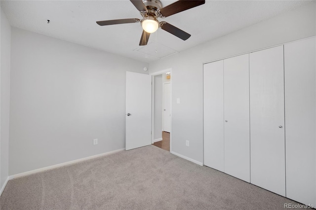 unfurnished bedroom featuring ceiling fan, a closet, and light carpet