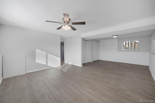 unfurnished room with ceiling fan, hardwood / wood-style floors, and a textured ceiling