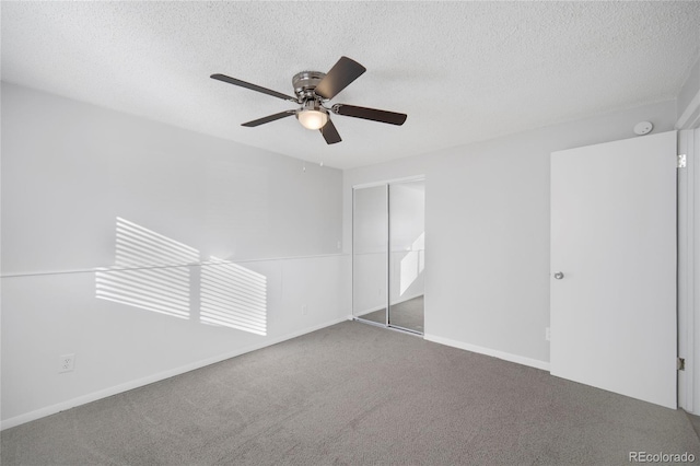 unfurnished bedroom featuring ceiling fan, carpet floors, a closet, and a textured ceiling