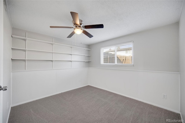 spare room featuring ceiling fan, carpet floors, and a textured ceiling