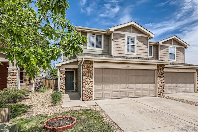 5957 Turnstone Pl, Castle Rock, CO 80104 - townhome / multi-family property with an attached garage, stone siding, driveway, and roof with shingles