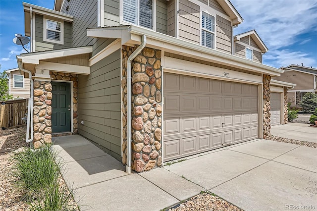 5957 Turnstone Pl, Castle Rock, CO 80104 - view of side of home featuring an attached garage, stone siding, and driveway