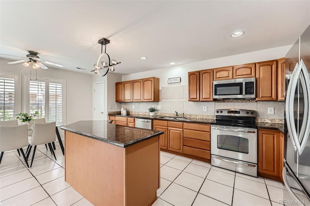5957 Turnstone Pl, Castle Rock, CO 80104 - kitchen with appliances with stainless steel finishes, a sink, tasteful backsplash, a center island, and decorative light fixtures