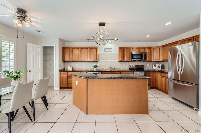 5957 Turnstone Pl, Castle Rock, CO 80104 - kitchen featuring stainless steel appliances, a center island, light tile patterned floors, hanging light fixtures, and recessed lighting