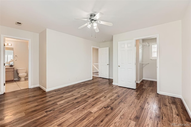 5957 Turnstone Pl, Castle Rock, CO 80104 - unfurnished bedroom featuring wood finished floors, baseboards, ensuite bathroom, a ceiling fan, and a spacious closet