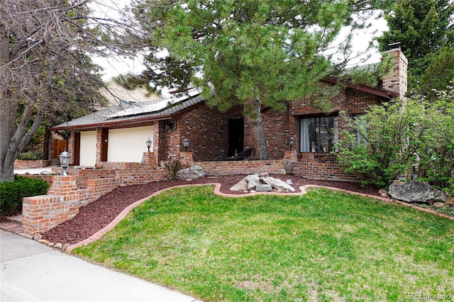 view of front facade featuring an attached garage, solar panels, a front lawn, and brick siding