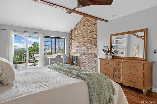 bedroom featuring lofted ceiling with beams, a brick fireplace, dark wood-style flooring, and access to exterior