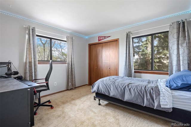 bedroom with baseboards, ornamental molding, carpet, and a closet