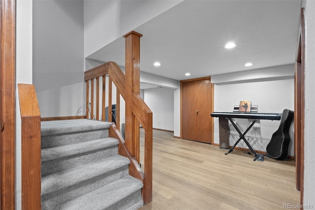 staircase with recessed lighting, baseboards, and wood finished floors