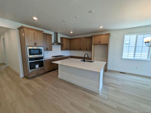 8326 Cokedale Cir, Littleton, CO 80125 - kitchen featuring appliances with stainless steel finishes, wall chimney range hood, a sink, baseboards, and light countertops