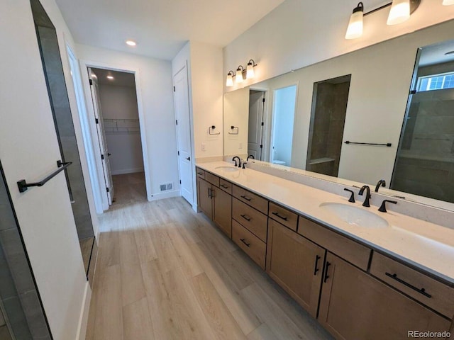 8326 Cokedale Cir, Littleton, CO 80125 - full bathroom featuring wood finished floors, double vanity, baseboards, a walk in closet, and recessed lighting