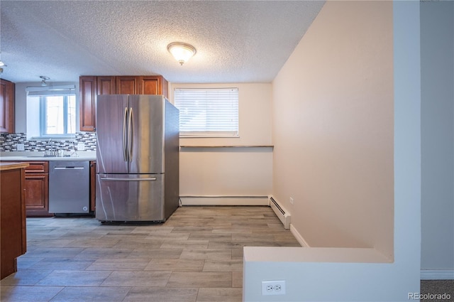 kitchen with backsplash, a wealth of natural light, stainless steel appliances, and a baseboard heating unit