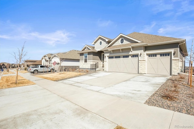 view of front of home with stone siding, an attached garage, concrete driveway, and roof with shingles