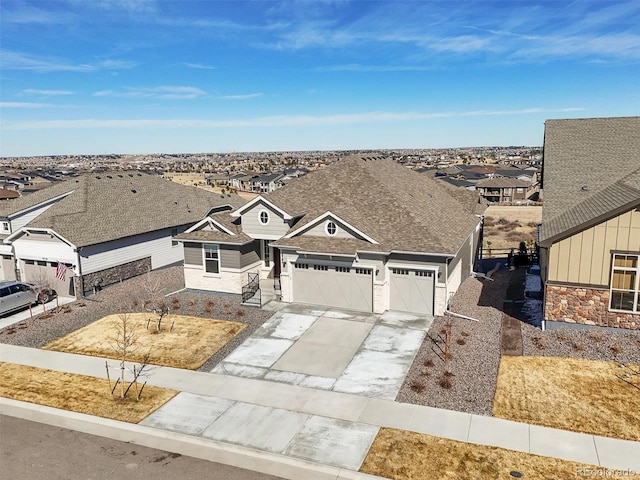single story home featuring roof with shingles, a residential view, concrete driveway, and stone siding