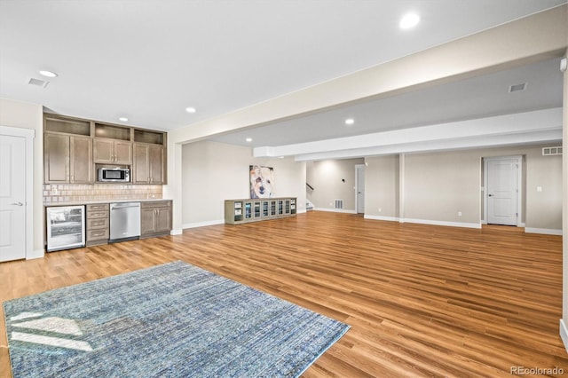 interior space with baseboards, recessed lighting, light wood-style flooring, stairs, and wine cooler