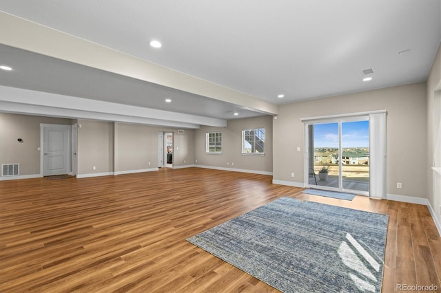 unfurnished living room with recessed lighting, light wood-style flooring, baseboards, and visible vents