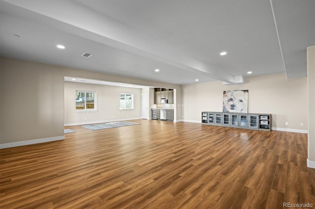 unfurnished living room featuring wood finished floors, baseboards, and recessed lighting