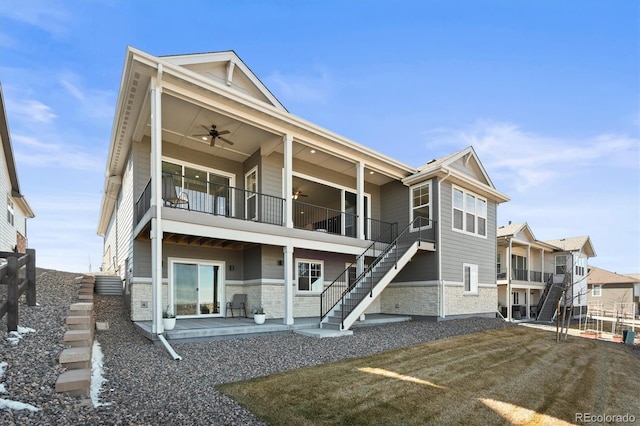 exterior space featuring a patio area, ceiling fan, stone siding, stairway, and a balcony