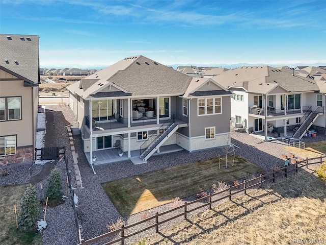 rear view of house featuring a residential view, stairway, a fenced backyard, and a patio