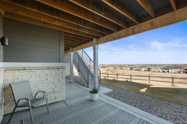 view of patio / terrace featuring stairway and fence