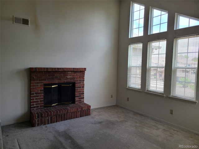 4760 S Wadsworth Unit 301, Littleton, CO 80123 - unfurnished living room with carpet flooring, a brick fireplace, and baseboards