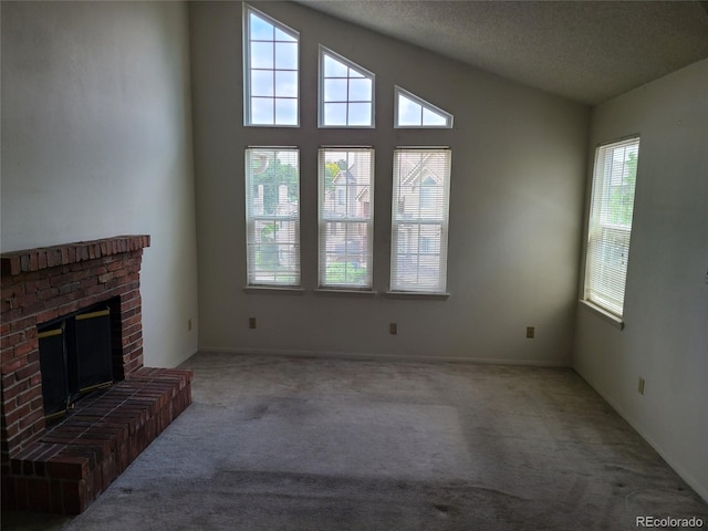 4760 S Wadsworth Unit 301, Littleton, CO 80123 - unfurnished living room with carpet flooring, a brick fireplace, a textured ceiling, and baseboards